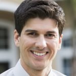 Mid adult man (30s) standing in front of house.
